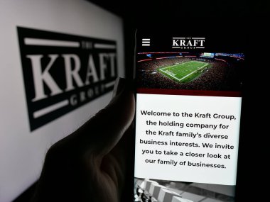 Stuttgart, Almanya - 05-15-2025: ABD holding şirketi Kraft Group LLC 'nin web sayfası ile akıllı telefon sahibi kişi logonun önünde ekranda. Telefon ekranının merkezine odaklan.