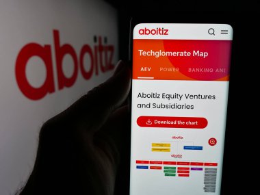 Stuttgart, Almanya - 05-15-2025: Logonun önünde Aboitiz Equity Ventures Inc. (AEV) adlı web sitesi bulunan kişi. Telefon ekranının merkezine odaklan.