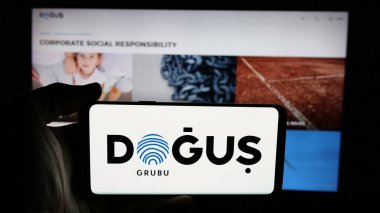 Stuttgart, Almanya - 05-16-2025: Türk Dogus Holding A.S. şirketinin logosunun bulunduğu cep telefonu web sayfası önünde ekranda. Telefon ekranına odaklan.