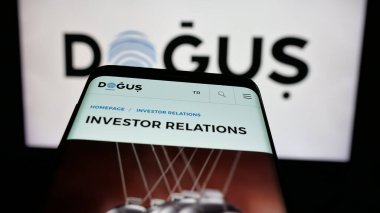 Stuttgart, Almanya - 05-16-2025: Türk Dogus Holding A.S. şirketinin web sitesi logonun önünde ekranda. Telefon ekranının sol üst kısmına odaklan.