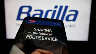Stuttgart, Almanya - 05-16-2025: İtalyan gıda işleme şirketi Barilla 'nın web sitesiyle birlikte logo önünde cep telefonu. Telefon ekranının sol üst kısmına odaklan.