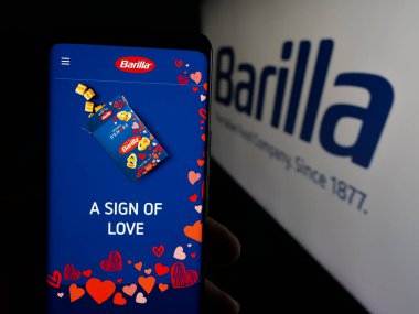 Stuttgart, Almanya - 05-16-2025: İtalyan gıda işleme şirketi Barilla 'nın internet sayfası olan cep telefonu logosu önünde ekranda. Telefon ekranının merkezine odaklan.