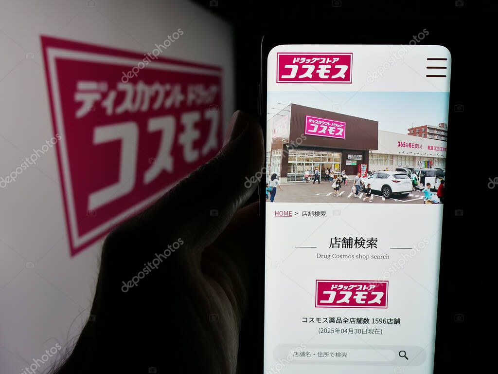 Stuttgart, Germany - 05-14-2025: Person holding web page with logo of Japanese company COSMOS Pharmaceutical Corp. on screen in front of logo. Focus on center of phone display.