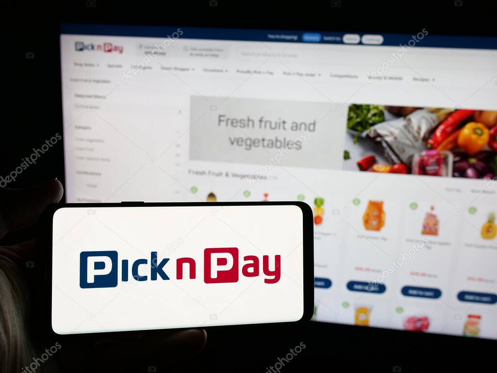 Stuttgart, Germany - 05-14-2025: Person holding smartphone with logo of grocery retail company Pick n Pay Group Ltd. on screen in front of website. Focus on phone display.