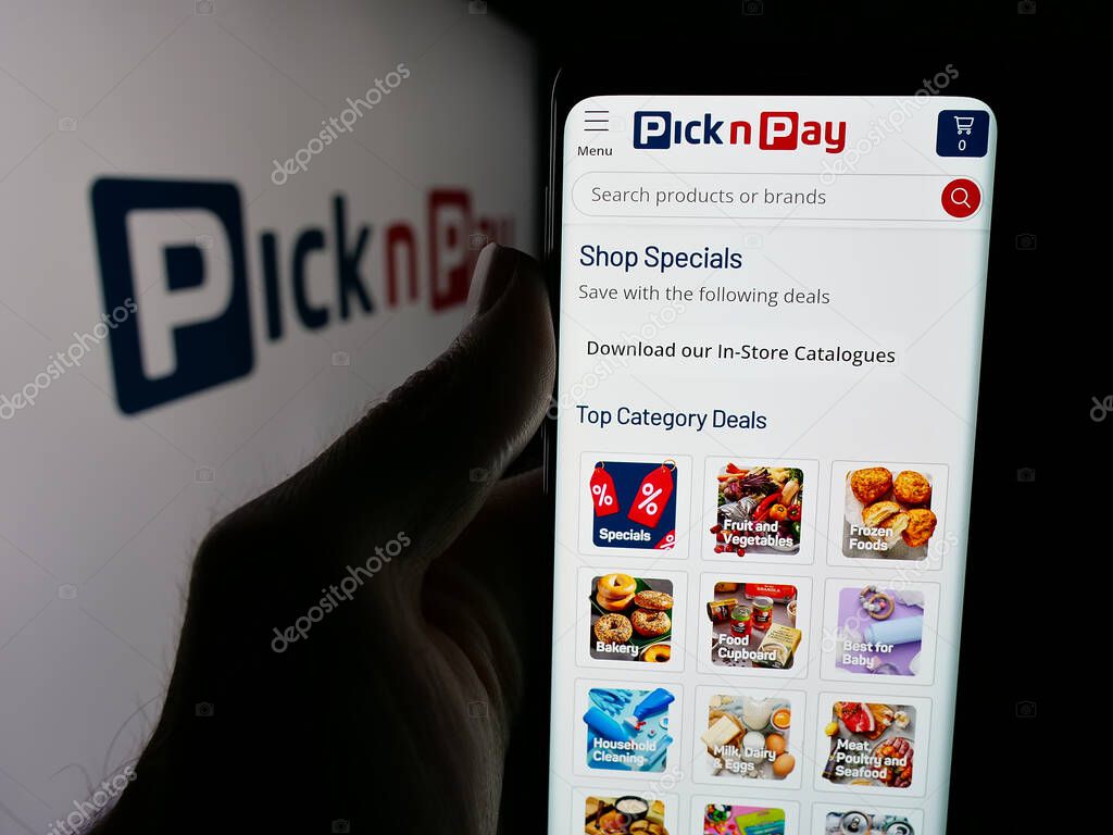 Stuttgart, Germany - 05-14-2025: Person holding web page with logo of grocery retail company Pick n Pay Group Ltd. on screen in front of logo. Focus on center of phone display.
