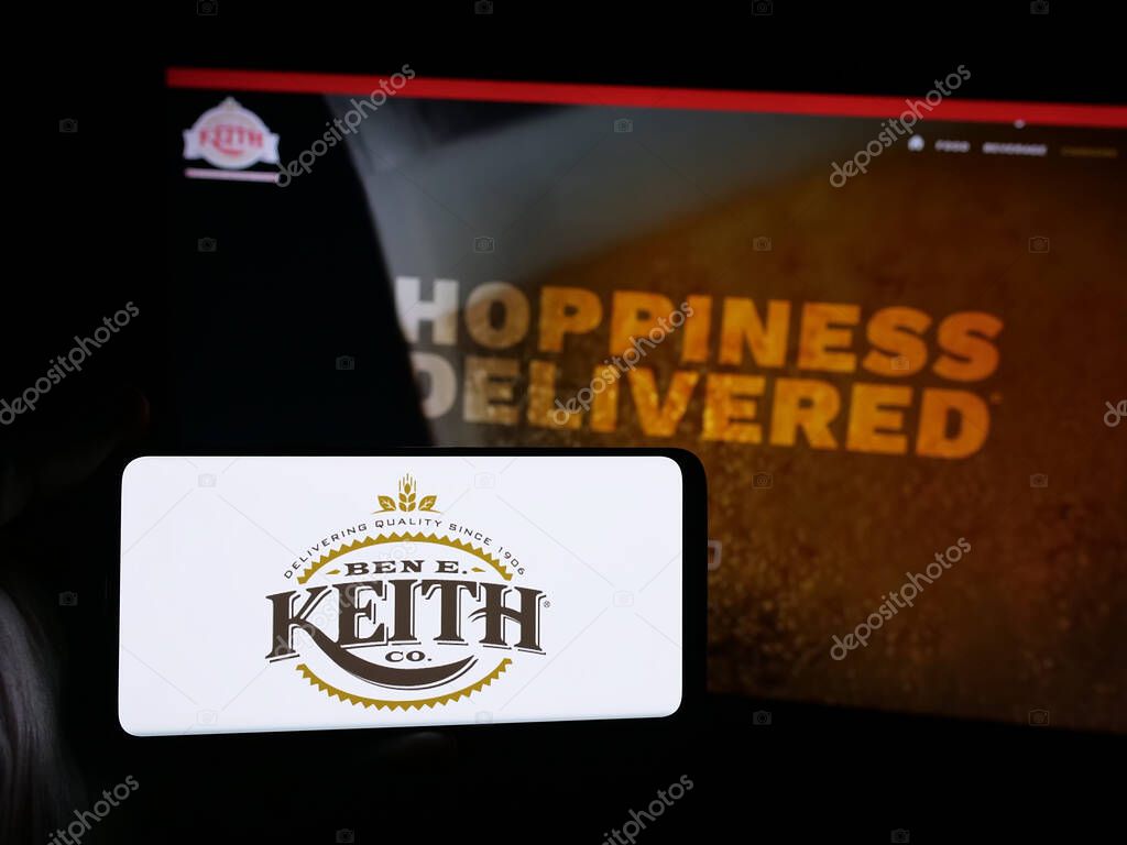 Stuttgart, Germany - 05-16-2025: Person holding smartphone with logo of US distribution business Ben E. Keith Company on screen in front of website. Focus on phone display.