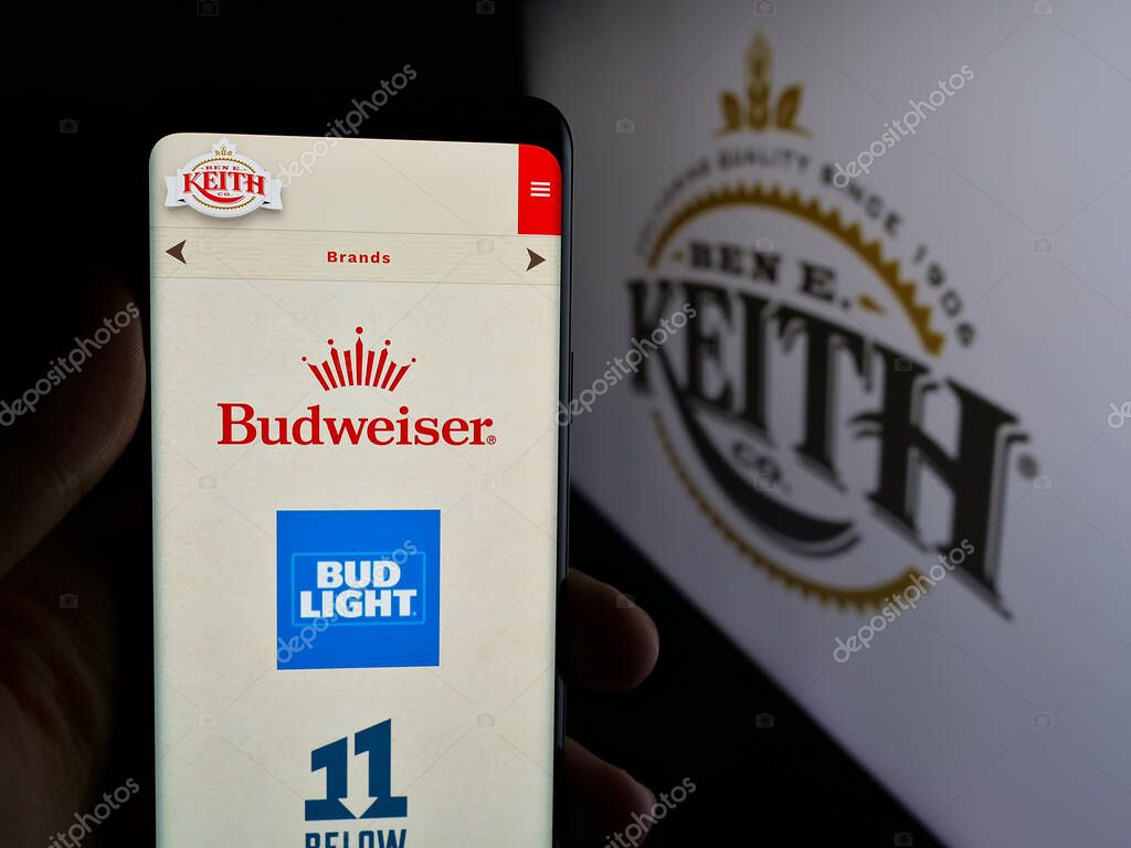 Stuttgart, Germany - 05-16-2025: Person holding cellphone with webpage of US distribution business Ben E. Keith Company on screen in front of logo. Focus on center of phone display.