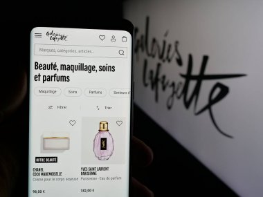Stuttgart, Almanya - 05-17-2025: Alışveriş merkezi şirketi Galeries Lafayette 'in web sayfası ile akıllı telefon taşıyan kişi logonun önünde ekranda. Telefon ekranının merkezine odaklan.