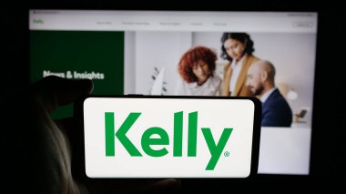 Stuttgart, Almanya - 05-17-2025: Web sayfası önünde ekranda ABD 'li personel şirketi Kelly Services Inc.' in logosuyla cep telefonu bulunduran kişi. Telefon ekranına odaklan.