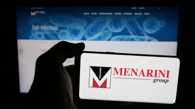 Stuttgart, Almanya - 05-17-2025: İtalyan ilaç şirketi Menarini Group 'un logosunun bulunduğu cep telefonu web sayfasının önünde ekranda. Telefon ekranına odaklan.