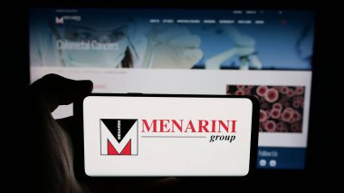 Stuttgart, Almanya - 05-17-2025: İtalyan ilaç şirketi Menarini Group 'un logosunun bulunduğu cep telefonu web sayfası önünde ekranda. Telefon ekranına odaklan.