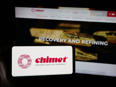 Stuttgart, Almanya - 05-17-2025: Metal işleme şirketi Chimet S.P.A. 'nın logosunu elinde tutan kişi web sitesinin önünde ekranda. Telefon ekranına odaklan.