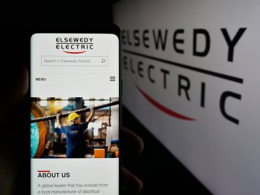 Stuttgart, Almanya - 05-17-2025: Mısırlı şirket Elsewedy Electric Co S.A.E. 'nin web sayfası ile akıllı telefon tutan kişi Ekranda logonun önünde. Telefon ekranının merkezine odaklan.