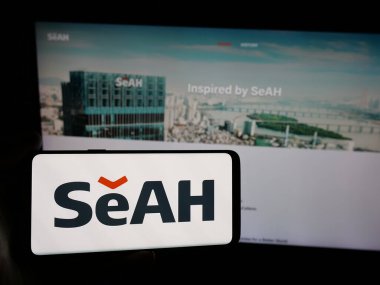 Stuttgart, Almanya - 05-17-2025: Koreli şirket SeAh Steel Holding 'in logosuna sahip akıllı telefon sahibi kişi web sitesinin önünde ekranda. Telefon ekranına odaklan.