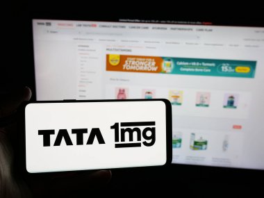 Stuttgart, Almanya - 05-18-2025: Hint sağlık platformu şirketi Tata 1 mg 'nin logosuna sahip akıllı telefon sahibi kişi web sitesinin önünde ekranda. Telefon ekranına odaklan.