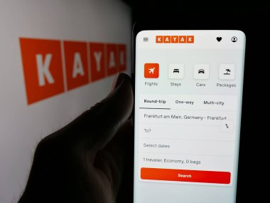 Stuttgart, Almanya - 05-18-2025: ABD 'li seyahat metasearch şirketi Kayak' ın web sayfası olan cep telefonu logosu önünde ekranda. Telefon ekranının merkezine odaklan.