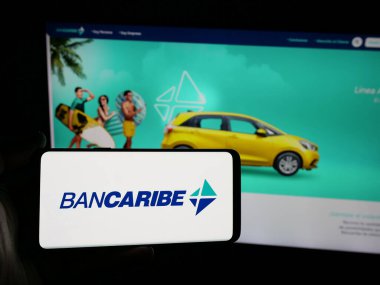 Stuttgart, Almanya - 05-18-2025: Banco del Caribe C.A. şirketinin logosunu taşıyan kişi (Bancaribe) Web sitesinin önünde ekranda. Telefon ekranına odaklan.