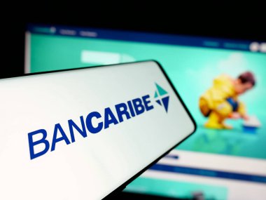 Stuttgart, Almanya - 05-18-2025: Banco del Caribe C.A. şirketinin logosuna sahip akıllı telefon (Bancaribe) Web sitesinin önünde ekranda. Telefon ekranının merkez soluna odaklan.