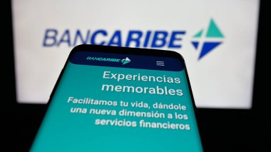 Stuttgart, Almanya - 05-18-2025: Banco del Caribe C.A. şirketinin web sitesiyle cep telefonu Logonun önündeki ekranda (Bancaribe). Telefon ekranının sol üst kısmına odaklan.