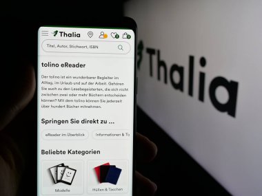 Stuttgart, Almanya - 05-25-2025: Alman kitapçı firması Thalia Buecher GmbH 'in internet sayfası ile akıllı telefon taşıyan kişi logonun önünde ekranda. Telefon ekranının merkezine odaklan.