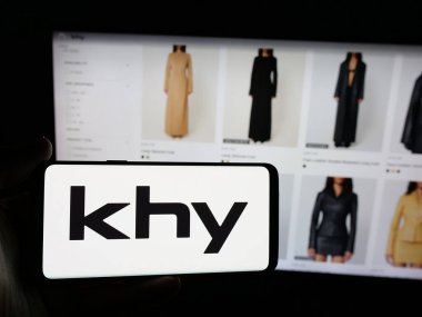 Stuttgart, Almanya - 05-25-2025: ABD 'li moda şirketi K Brand Inc.' in logosuna sahip akıllı telefon sahibi kişi web sitesinin önünde ekranda. Telefon ekranına odaklan.