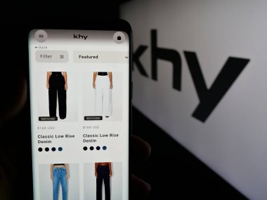 Stuttgart, Almanya - 05-25-2025: ABD 'li moda şirketi K Brand Inc. (Khy)' in web sayfası olan akıllı telefon sahibi kişi logonun önünde ekranda. Telefon ekranının merkezine odaklan.