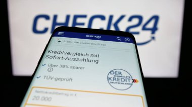 Stuttgart, Almanya - 05-25-2025: Alman fiyat karşılaştırma şirketi Check24 GmbH 'nin web sitesi bulunan cep telefonu logonun önünde ekranda. Telefon ekranının sol üst kısmına odaklan.