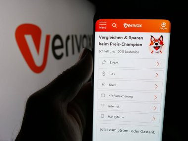 Stuttgart, Almanya - 05-25-2025: Alman fiyat karşılaştırma şirketi Verivox GmbH 'nin web sayfası ile akıllı telefon sahibi kişi logonun önünde ekranda. Telefon ekranının merkezine odaklan.