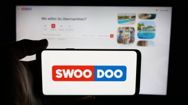 Stuttgart, Almanya - 05-25-2025: Uçuş arama platformu logosu SWOODOO 'nun logosuna sahip cep telefonu web sayfasının önünde. Telefon ekranına odaklan.