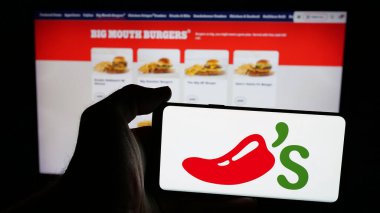 Stuttgart, Almanya - 05-25-2025: ABD 'li restoran zinciri şirketi Chili' s Grill Bar 'ın logosunun bulunduğu cep telefonu web sayfasının önünde duruyor. Telefon ekranına odaklan.