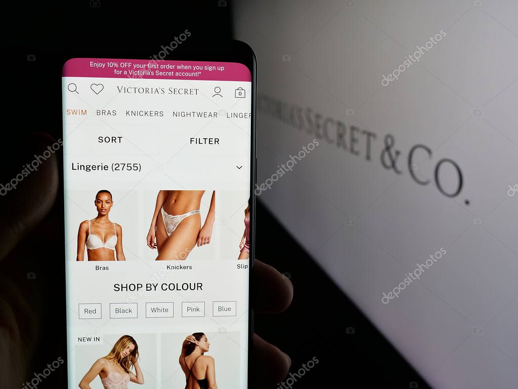 Stuttgart, Germany - 05-18-2025: Person holding smartphone with web page of US lingerie company Victoria's Secret Co. on screen in front of logo. Focus on center of phone display.