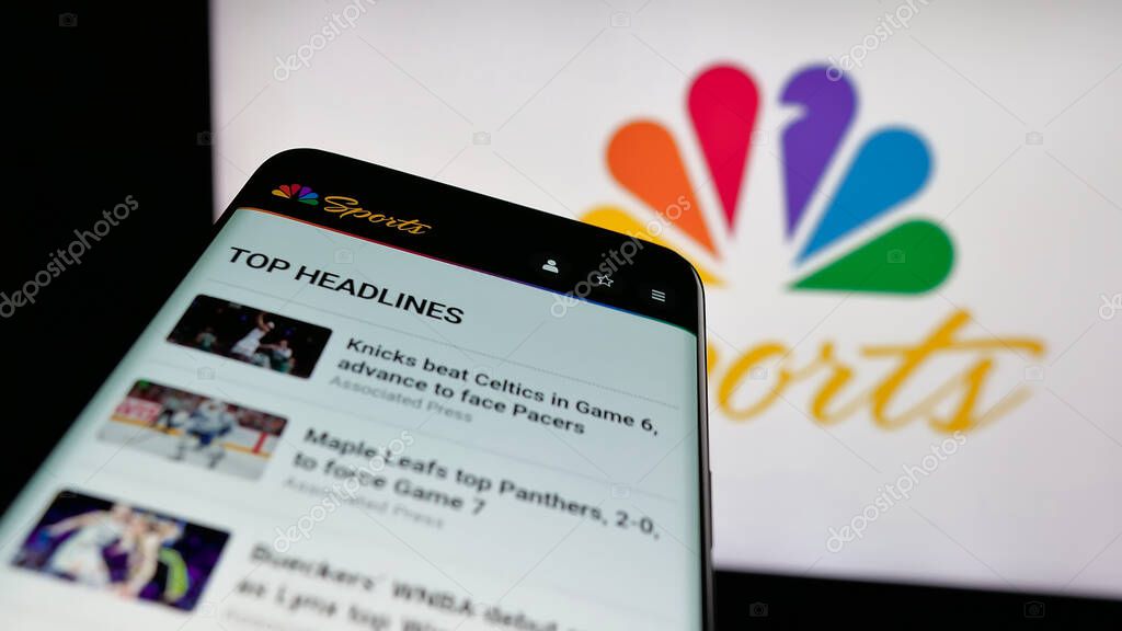 Stuttgart, Germany - 05-25-2025: Mobile phone with website of US television channel NBC Sports (NBCSports) on screen in front of logo. Focus on top-left of phone display.