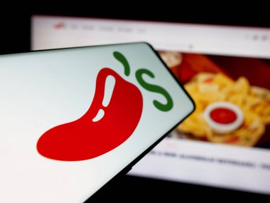 Stuttgart, Almanya - 05-25-2025: İnternet sitesinin önünde ABD 'li restoran zinciri Chili' s Grill Bar 'ın logosuna sahip akıllı telefon. Telefon ekranının merkezine odaklan.