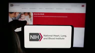 Stuttgart, Almanya - 05-25-2025: ABD sağlık enstitüsü NHLBI logosu olan cep telefonu web sayfası önünde ekranda. Telefon ekranına odaklan.