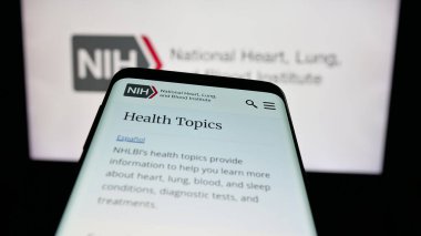 Stuttgart, Almanya - 05-25-2025: ABD sağlık enstitüsü NHLBI 'ın web sitesi bulunan cep telefonu logonun önünde ekranda. Telefon ekranının sol üst kısmına odaklan.