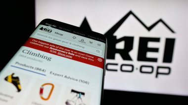 Stuttgart, Almanya - 05-25-2025: Logo önünde ekranda, ABD 'li bir şirketin internet sitesi olan cep telefonu. (REI) Telefon ekranının sol üst kısmına odaklan.