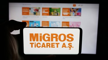 Stuttgart, Almanya - 05-25-2025: Türk perakende şirketi Migros Ticaret A.S. 'in logosunun bulunduğu cep telefonu web sayfası önünde ekranda. Telefon ekranına odaklan.