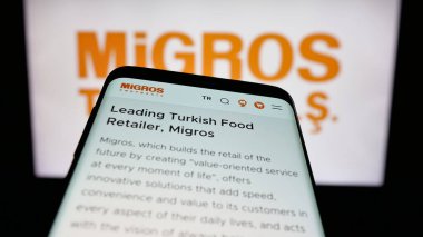 Stuttgart, Almanya - 05-25-2025: Türk perakende şirketi Migros Ticaret A.S. 'in web sitesiyle birlikte cep telefonu logonun önünde ekranda. Telefon ekranının sol üst kısmına odaklan.