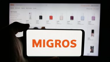 Stuttgart, Almanya - 05-25-2025: İsviçreli süpermarket şirketi Migros 'un logosunun bulunduğu cep telefonu web sayfası önünde ekranda. Telefon ekranına odaklan.