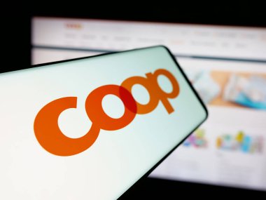 Stuttgart, Almanya - 05-26-2025: İsviçreli perakende şirketi Coop Genossenschaft 'ın logosuna sahip akıllı telefon web sitesinin önünde ekranda. Telefon ekranının merkez soluna odaklan.