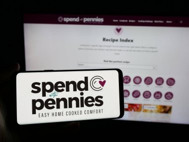 Stuttgart, Almanya - 05-26-2025: İnternet sitesi önünde üzerinde Harcama Bozukluklarla Harca (SWP Media Ltd.) logosu olan akıllı telefon sahibi kişi. Telefon ekranına odaklan.