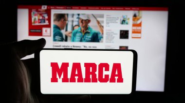 Stuttgart, Almanya - 05-27-2025: İspanyol günlük spor gazetesi Marca 'nın logosunun bulunduğu cep telefonu web sayfası önünde ekranda. Telefon ekranına odaklan.