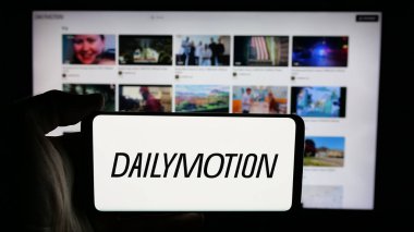 Stuttgart, Almanya - 05-27-2025: İnternet sayfasının önünde Fransız video paylaşım şirketi Dailymotion S.A. 'nın logosuyla cep telefonu tutan kişi. Telefon ekranına odaklan.
