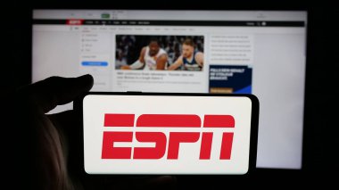 Stuttgart, Almanya - 05-27-2025: İnternet sayfası önünde ekranda ABD kablolu televizyon kanalı ESPN 'nin logosuyla cep telefonu tutan kişi. Telefon ekranına odaklan.