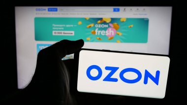 Stuttgart, Almanya - 05-27-2025: İnternet sayfasındaki ekranda Rus e-ticaret şirketi Özon 'un (Özon.ru) logosuna sahip cep telefonu sahibi kişi. Telefon ekranına odaklan.