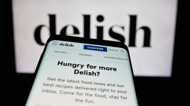 Stuttgart, Almanya - 05-27-2025: ABD gıda çevrimiçi dergisi Delish.com 'un (Hearst) yer aldığı cep telefonu logonun önünde ekranda. Telefon ekranının sol üst kısmına odaklan.