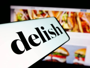 Stuttgart, Almanya - 05-27-2025: İnternet sitesi önünde ABD gıda çevrimiçi dergisi Delish.com (Hearst) logosu bulunan akıllı telefon. Telefon ekranının merkez soluna odaklan.