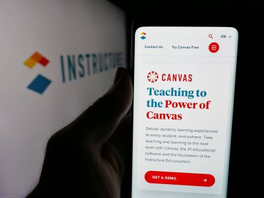 Stuttgart, Almanya - 05-27-2025: ABD 'li Edtech şirketi Instructure Holding Inc.' nin web sayfası ile akıllı telefon sahibi kişi logonun önünde ekranda. Telefon ekranının merkezine odaklan.