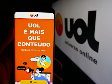 Stuttgart, Almanya - 05-27-2025: Brezilya web platformu Universo Online 'ın (UOL) web sayfası olan cep telefonu logosu önünde ekranda. Telefon ekranının merkezine odaklan.