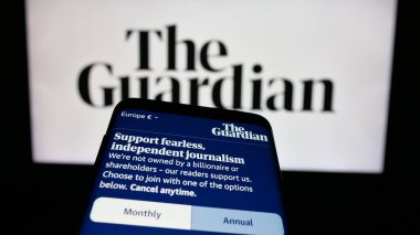 Stuttgart, Almanya - 05-27-2025: İngiliz gazete şirketi The Guardian 'ın web sitesiyle birlikte logo önünde cep telefonu. Telefon ekranının sol üst kısmına odaklan.